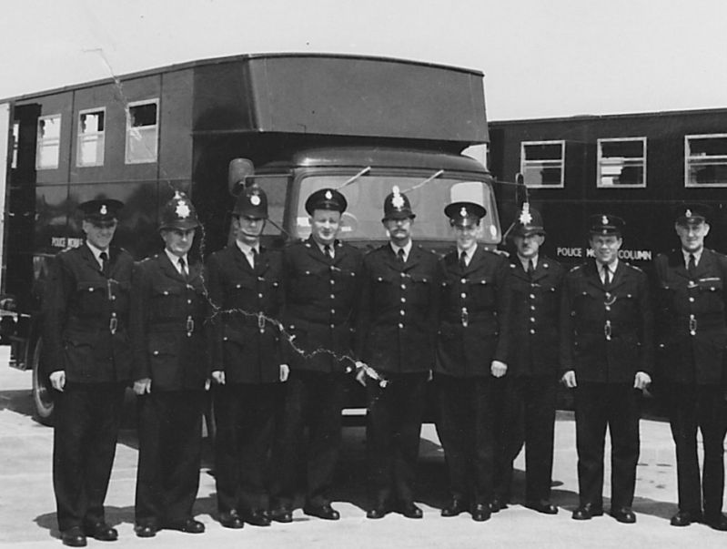 Mobile Column exercise
The Mobile Column exercise took place at Bovington Camp, Dorset in July 1965 and the actual exercise on Portland terminated with a parade on Weymouth sea-front. In the lineup in front of the van (in which we lived on exercise) I am flat capped 4th from right, Inspector Reg Gale, (Hants) is at the extreme left and also in the picture is Pc "Bud" Abbott, also from Hants. Submitted by David France
