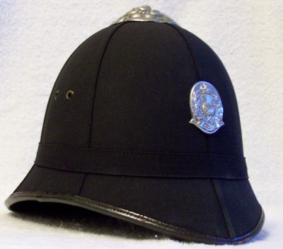 Edinburgh City Police Helmet, 1932 - 1951
Edinburgh City Police Helmet, 1932 - 1951. Cork helmet covered with smooth cloth in the Scottish style, plain cloth centre band, detailed chrome top rose with no ventilation holes (although the type with vent holes is known to exist. Scottish National Police Badge introduced in 1932 which superseded the Edinburgh City Police Coat of Arms. Two vent holes either side of the helmet 
Keywords: Edinburgh Headwear