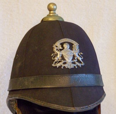 Manchester City Summer helmet pre-1938
Manchester City Summer helmet pre-1938, six panel design in smooth cloth with black leather centre band, white metal balltop and two piece Coat of Arms helmet plate with scroll "Manchester" above. Helmet body is made of straw with cloth covering
Keywords: manchester helmets Headwear