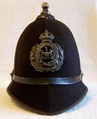 Newcastle Upon Tyne Night Helmet, circa early 1930's
Newcastle Upon Tyne Night Helmet, circa early 1930's, six panel design with black leather centre band. Blackened balltop, ear rosettes and helmet plate using a very thick black paint. Helmet plate is the slightly larger style with only one hole shown in the garter after the word 'Tyne' which was worn before the slightly smaller type introduced in the early 1930's.
Keywords: newcastle helmet Headwear
