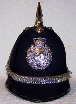 Worcester City Helmet, 1960's
Worcester City Helmet, 1960's, cork helmet covered in smooth blue cloth in four panel sections, chromed helmet plate, top spike and base, ear rosettes and chinchain (which hooks up at the rear)
Keywords: Worcester helmet Headwear