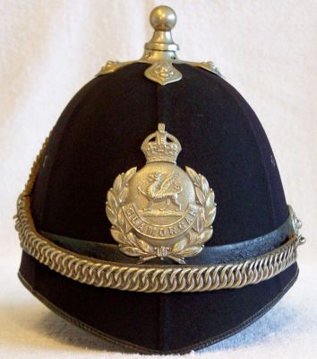 Glamorgan Constabulary Chained Helmet, 1930
Glamorgan Constabulary Chained Helmet, 1930, six panel design with black leather centre band and white metal balltop with cross base, ear rosettes with chinchain and helmet plate. White stencilled inside "GC F596 1930". Belonged to Sgt G Williams
Keywords: glamorgan chained helmet Headwear