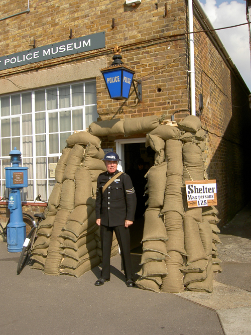 Wartime Museum
The Historic Dockyard, in Chatham, has a "Salute to the 40's" weekend in September and this year, 2008, it was decided to acquire sandbags and make the museum look as though it was a wartime police station. Curator John Endicott is seen here with his Tin hat and Gas mask. The 'shelter' sign hanging on the sandbags fooled lots of visitors who went to see where the shelter was !
Keywords: sandbags wartime salute tin hat gas mask