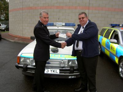 'TUG' returns home.
Kent Ford Granada Patrol Car, B773 YKL, Fleet number 88FG which finished its service with Kent Traffic Division, has come home again after complete restoration by ex Sussex PC Tim Smith. In this picture we see the Kent Police Museum Curator, John Endicott, handing over the cheque for the car at Coldharbour Traffic garage, where 'TUG' was based. John used to drive this car on duty, when not riding his motorcycle. John says, "It's in better nick now that when we had it!"
Keywords: Ford, Granada, Tug, Coldharbour, Museum Kent Vehicles
