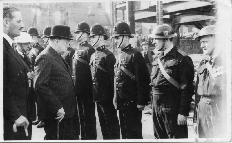 BIRMINGHAM CITY POLICE, PC 157E, THOMAS HENWOOD G.M.
Photo shows Winston Churchill meeting PC Henwood, on 30/October/1941.
On the back of the card is written, along with the date, 'with the complements of Tom Henwood'.
The London Gazette of 17th June 1941 has the following entry:
Thomas Montague William Henwood, Police Constable, Birmingham Police Force.
Police Constable Henwood has shown outstanding bravery and initiative during enemy air attacks on Birmingham.
On one occasion he went to a wrecked house where two persons were trapped.
Henwood began moving the debris and, after working for about half-an-hour, he succeeded in releasing a woman.
During this time high explosive bombs fell nearby and part of the wall of another house collapsed close to him.
Despite this, he continued his efforts and rescued another casualty.
Owing to the dangerous condition of the surrounding buildings PC Henwood allowed no one to work with him and it was by his efforts alone that the two persons were rescued.
