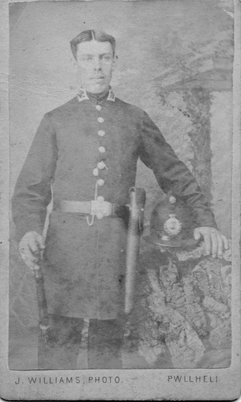 CAENARVONSHIRE CONSTABULARY, PC 43
Photo by: Jane Williams of Pwllheli.
The number 43 is visible on the helmet plate.
He is holding a truncheon in his right hand that may have some decoration on it.
