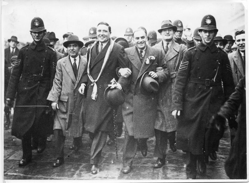 METROPOLITAN POLICE J DIVISION
Photo by: Special Press of 13 Johnson's Court, Fleet Street, E.C.$.
Looks like a political demonstration/march.
Could possibly be Irish related, looking at the sash worn by the civilian.
