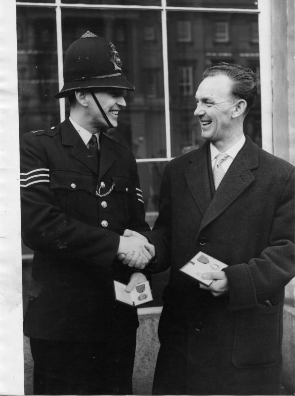 METROPOLITAN POLICE GEORGE MEDAL WINNERS 1956
Shown are Sgt. Norman George LOXLEY and Cst. Thomas OLIVER receiving the George Medal on 27th November 1956.
On the 2nd of December 1956 they responded to a fatal train crash at Barnes. As a result of their actions both men were awarded the George Medal.
For the citation see the London Gazette supplement of 5th of October 1956.
