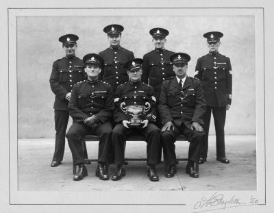 METROPOLITAN POLICE SPECIAL CONSTABULARY GROUP 'M' DIVISION
No photographer shown, but picture dated 1950.
They are wearing WW2 medals as well as the Special Constabulary Long Service.
Back row: PC 101; 121; 145; Sgt. 1
Front row: Inspector; Sgt. 8; possibly Supt.
This last man is wearing a very unusual cap badge, believed to be a senior officer type.
