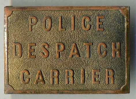 Police Despatch Carrier
Made of brass, it has two metal loops for a belt to go through.  Not sure which force or when they were used.
Keywords:  Buckle