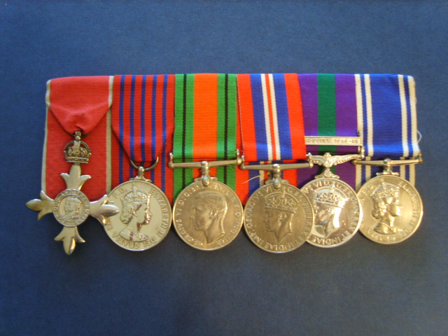 A very rare gallantry medal group worn by a now retired Gloucestershire Police Officer
M.B.E. / GEORGE MEDAL / DEFENCE MEDAL / 1939-45 WAR MEDAL / G.S.M. (Palestine 1945-48 bar) MEDAL / POLICE LONG SERVICE & GOOD CONDUCT MEDAL

Keywords: Gloucestershire