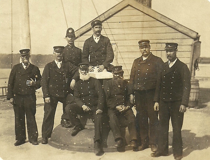 Workers at Sharpness Docks, Gloucestershire, circa 1908
3rd from left is a Police Constable, on both sides of his collar are the chrome letters SD (Sharpness Docks), he has a black helmet plate, (the same style as the Gloucestershire Constabulary plate of that time), but in the centre it again has the chrome letters SD. 
Keywords: Gloucestershire Sharpness Docks Police