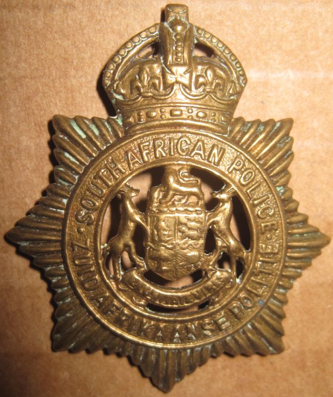 Brass Cap Badge worn by European O/R's of the South African Police from 1913 to 1926 
European members of the SA Police wore Brass Insignia until 1977 when all races wore insignia in a "gilt" finish. This Cap Badge was worn before the change over from Dutch to Afrikaans as the second official language in 1925 when the Dutch 'Zuid Afrikaanse Politie' was replaced with 'Suid Afrikaanse Poliesie'. It was worn until 1931 when the  Afrikaans spelling of the word "Polisie" was deemed to be correct and taken into general use.
Keywords: South African Police Brass Cap Badge European O/R&#039;s 1913 1926